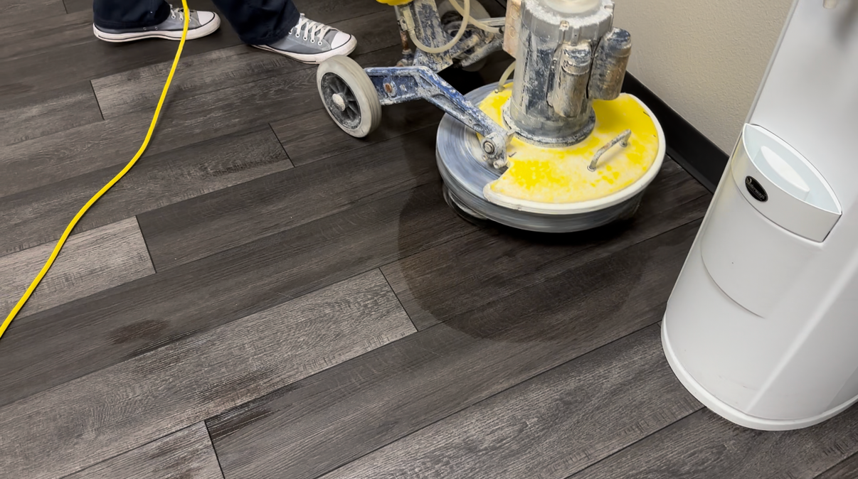 Commercial floor cleaning crew applying ceramic vinyl sealer in a Bradenton facility hallway