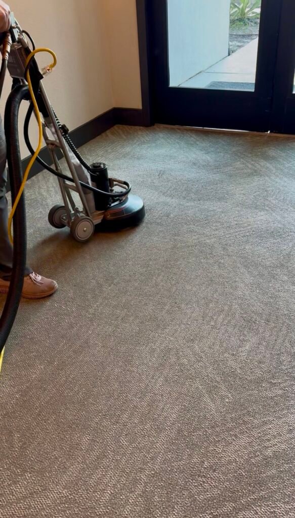 Carpet cleaning machine working by a patio door