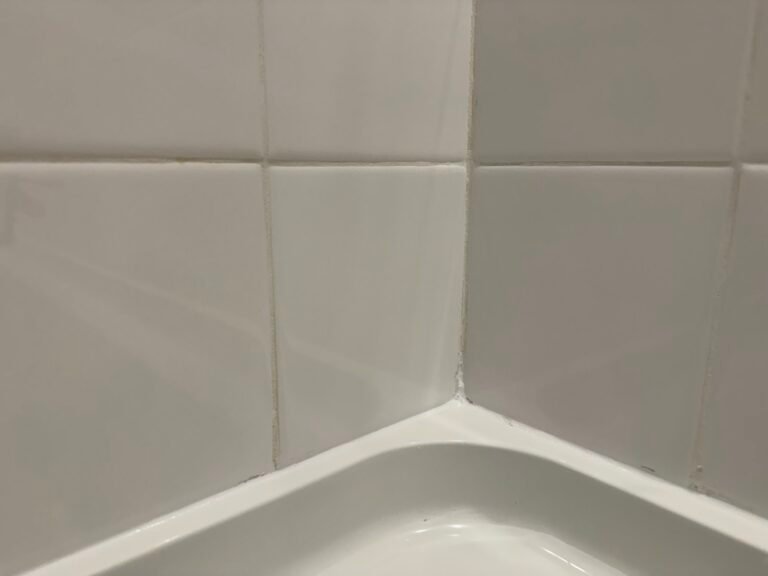 New caulk line where the shower wall tile meets the tub