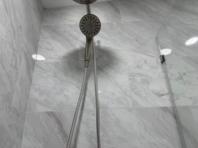 Shower handheld fixture and head on a restored tile wall