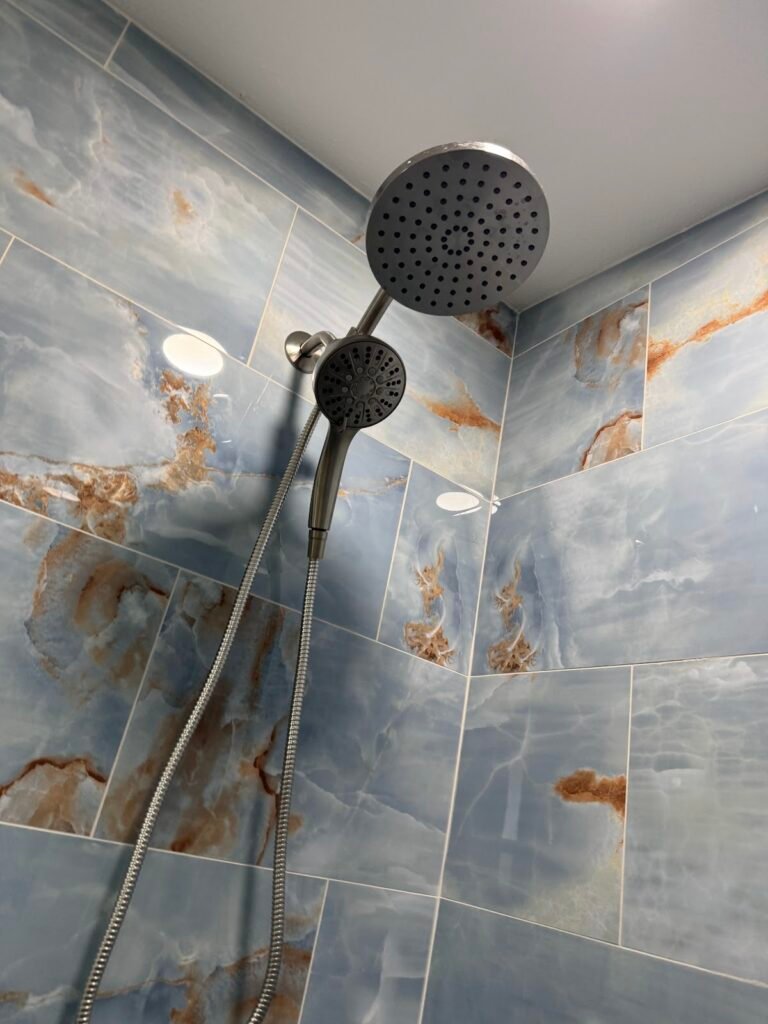 Restored tile shower with rain shower head and clean grout lines