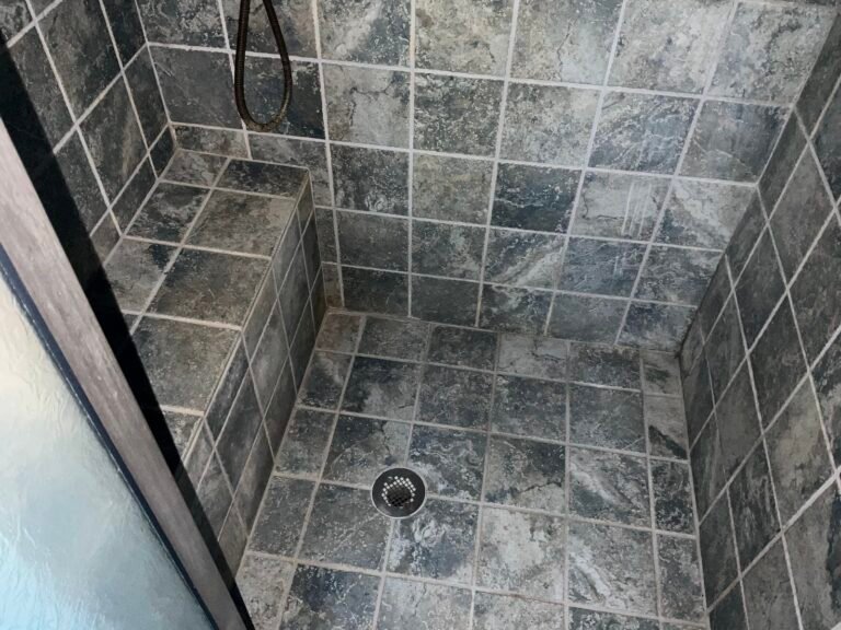 Tile shower with bench after grout restoration